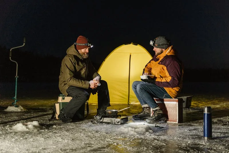 Fishing bivvy tent shelter pitched on grass near water for carp anglers